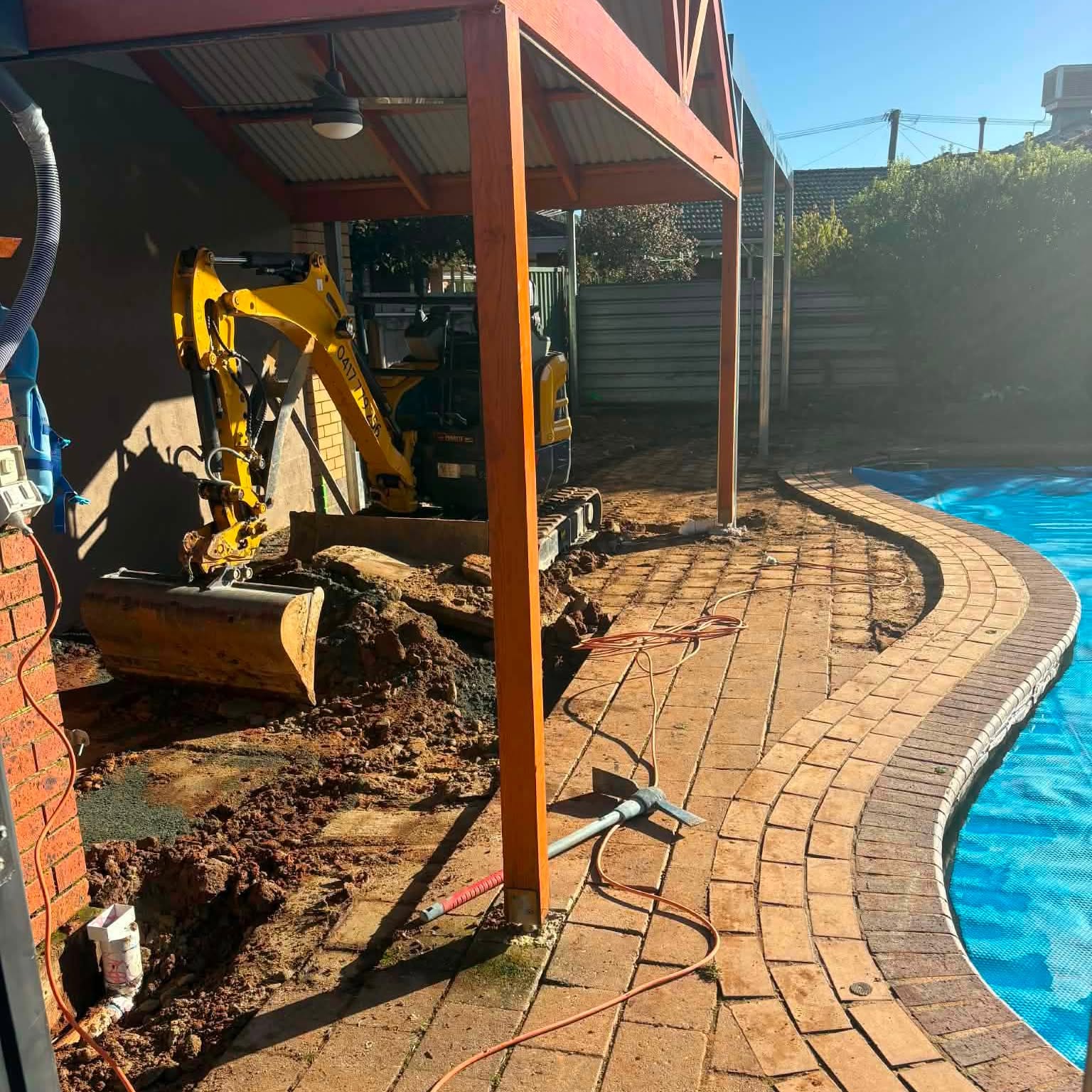 Excavator preparing ground for a concrete pool surround