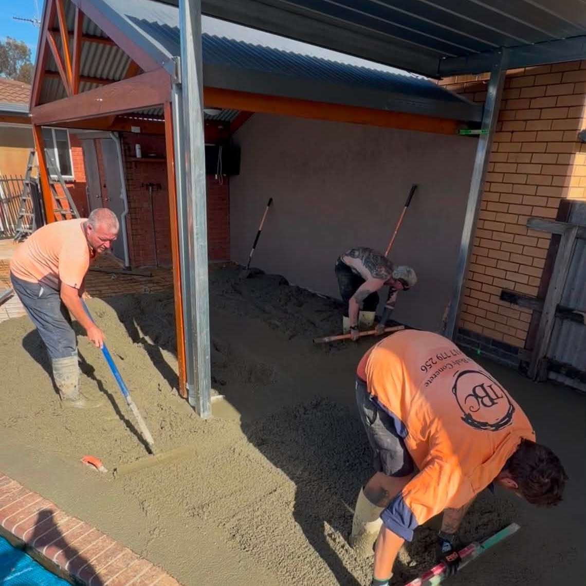Tom Body Concrete crew screeding a fresh concrete pour beside a home in Kyabram