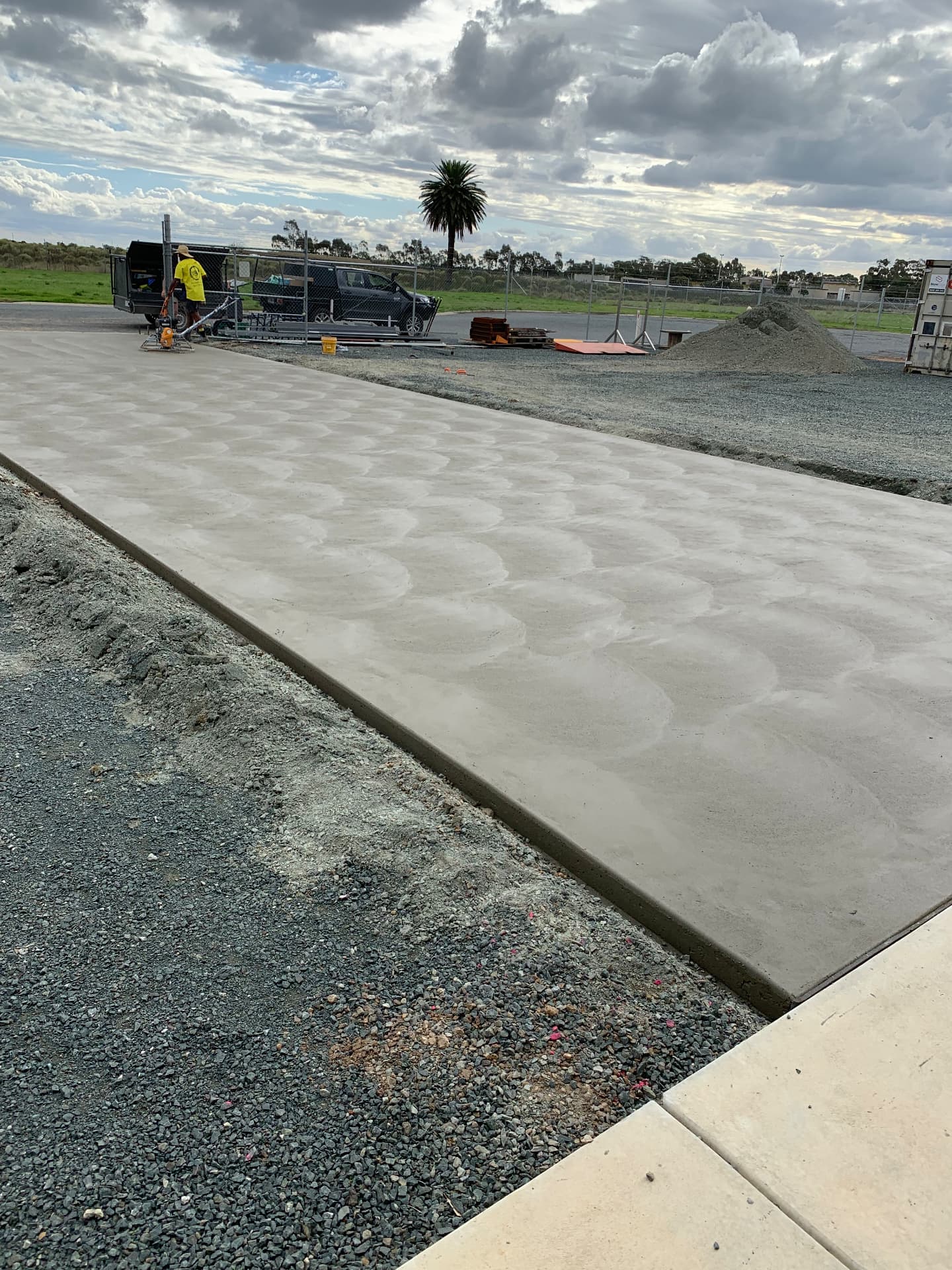 Large-scale commercial concrete pavement being power-trowelled to finish